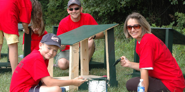 Mom, Dad and son working together to build an outdoor cat shelter
