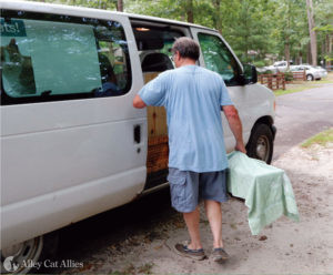 A man places a humane box trap in a van